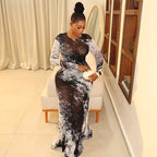 A woman wearing a sheer, black-and-white abstract print long-sleeve maxi dress with a body-hugging hip silhouette.
