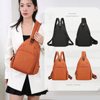 Woman wears a waterproof orange crossbody backpack with side pockets and buckles. Available in black and orange options.