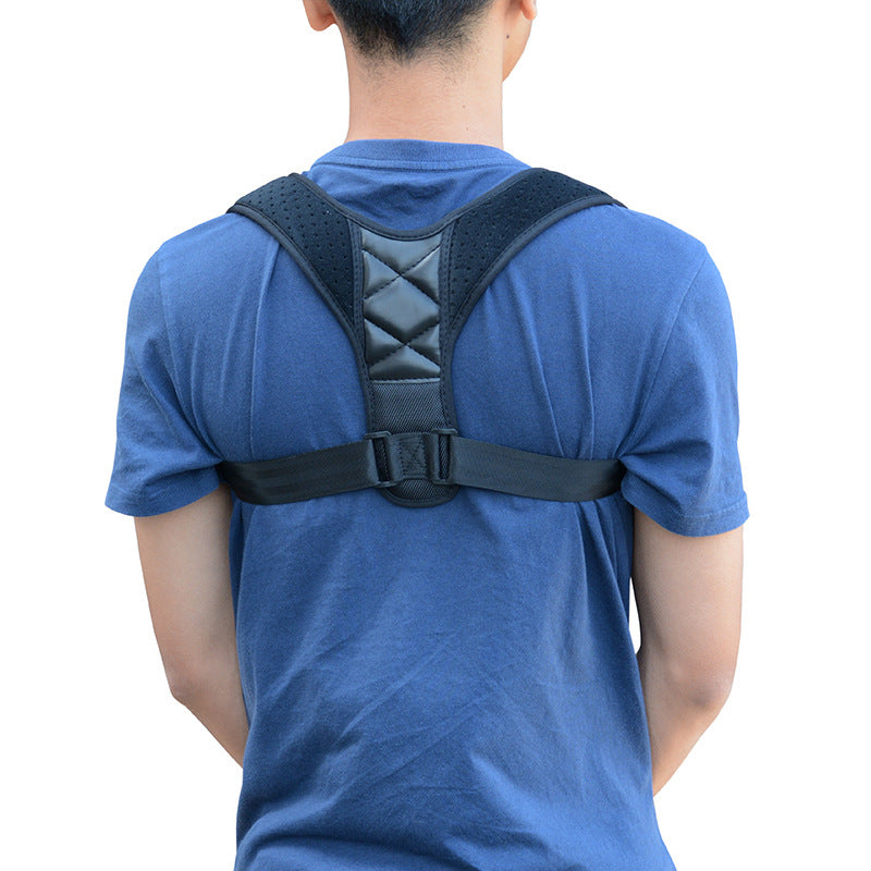 Black posture corrector brace over a blue t-shirt, featuring adjustable straps and cushioned shoulder pads.