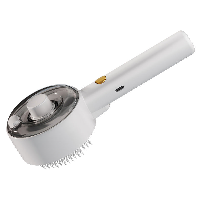 White steam pet grooming brush with a gold power button, translucent cap, and fine metal bristles for hair removal.