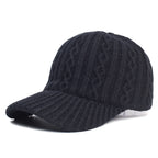 A black, cable-knit wool baseball cap featuring a ribbed brim and a cozy, textured design.