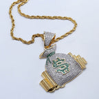 Gold rope chain with a rhinestone-encrusted money bag pendant featuring a green stone dollar sign and gold accents.