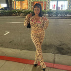 A woman wears a leopard-print zip-up jacket and matching high-waist tight trousers with pink embroidered lettering.