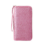 Pink glittery zip-around women's clutch wallet featuring a convenient matching wrist strap, isolated on white.