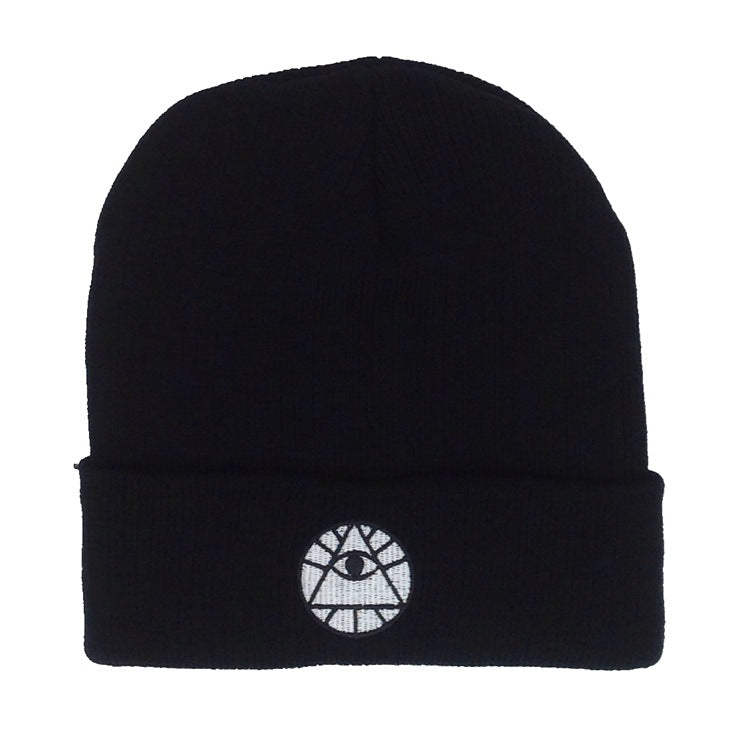 Black knit cuffed beanie featuring a white embroidered all-seeing eye pyramid symbol on the front.