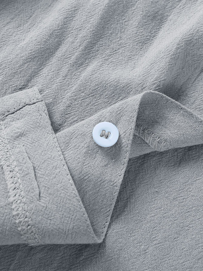 Close-up of a light gray, textured cotton-blend casual shirt with a single matching button on the collar placket.