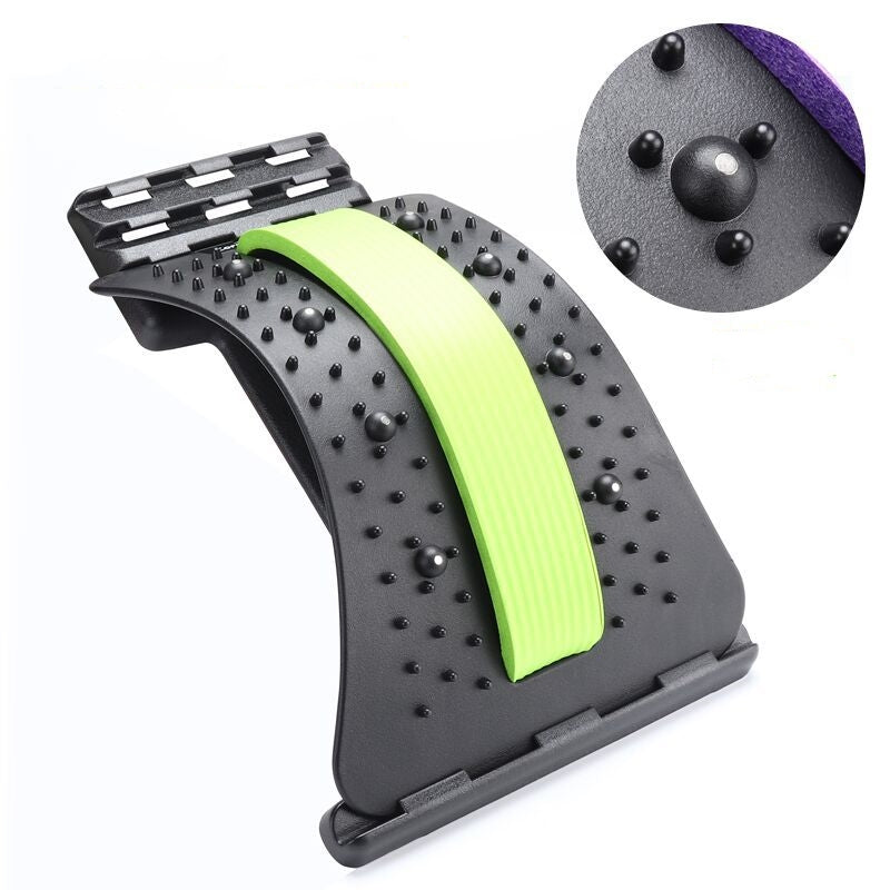Black plastic lumbar spine stretcher with a green foam strip and acupressure massage nubs for back pain relief.