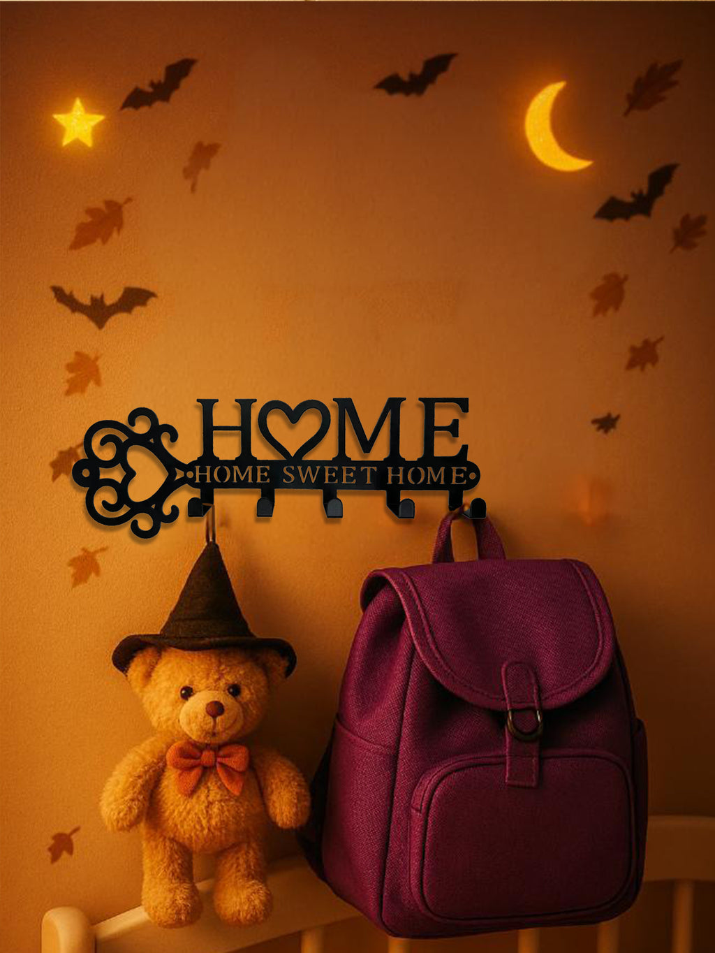 Black metal "Home" wall hooks shaped like a key with a heart, featuring five hooks, hanging on an orange Halloween wall.