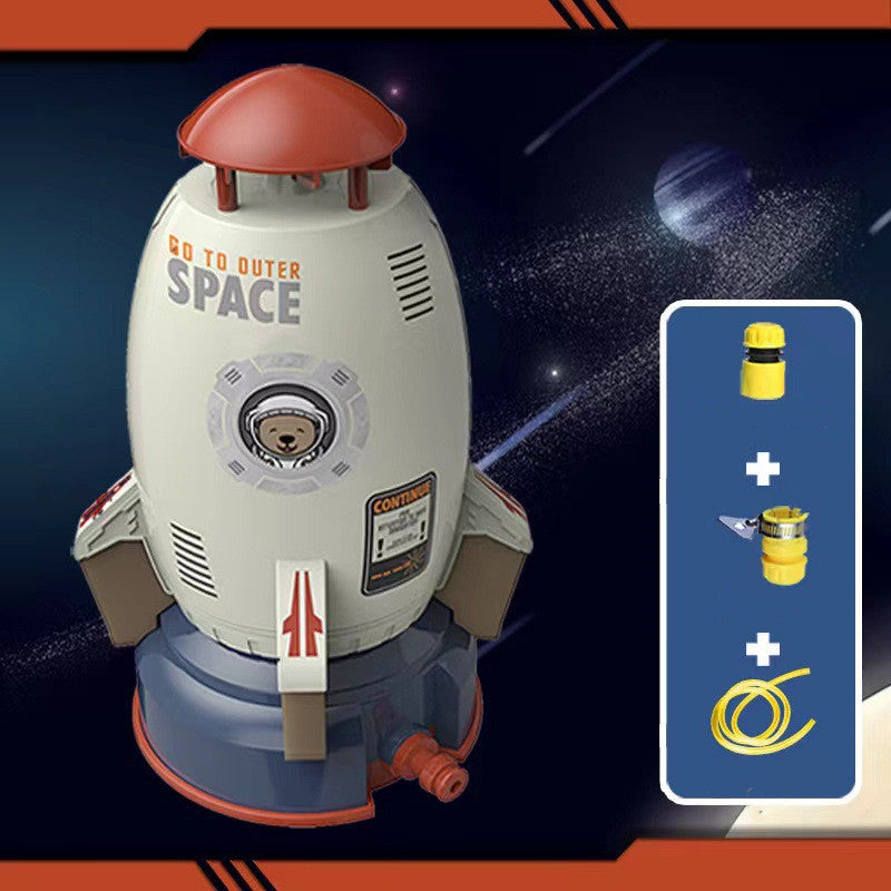 White and grey rocket water sprinkler toy with a bear astronaut graphic, red accents, and included hose attachments.