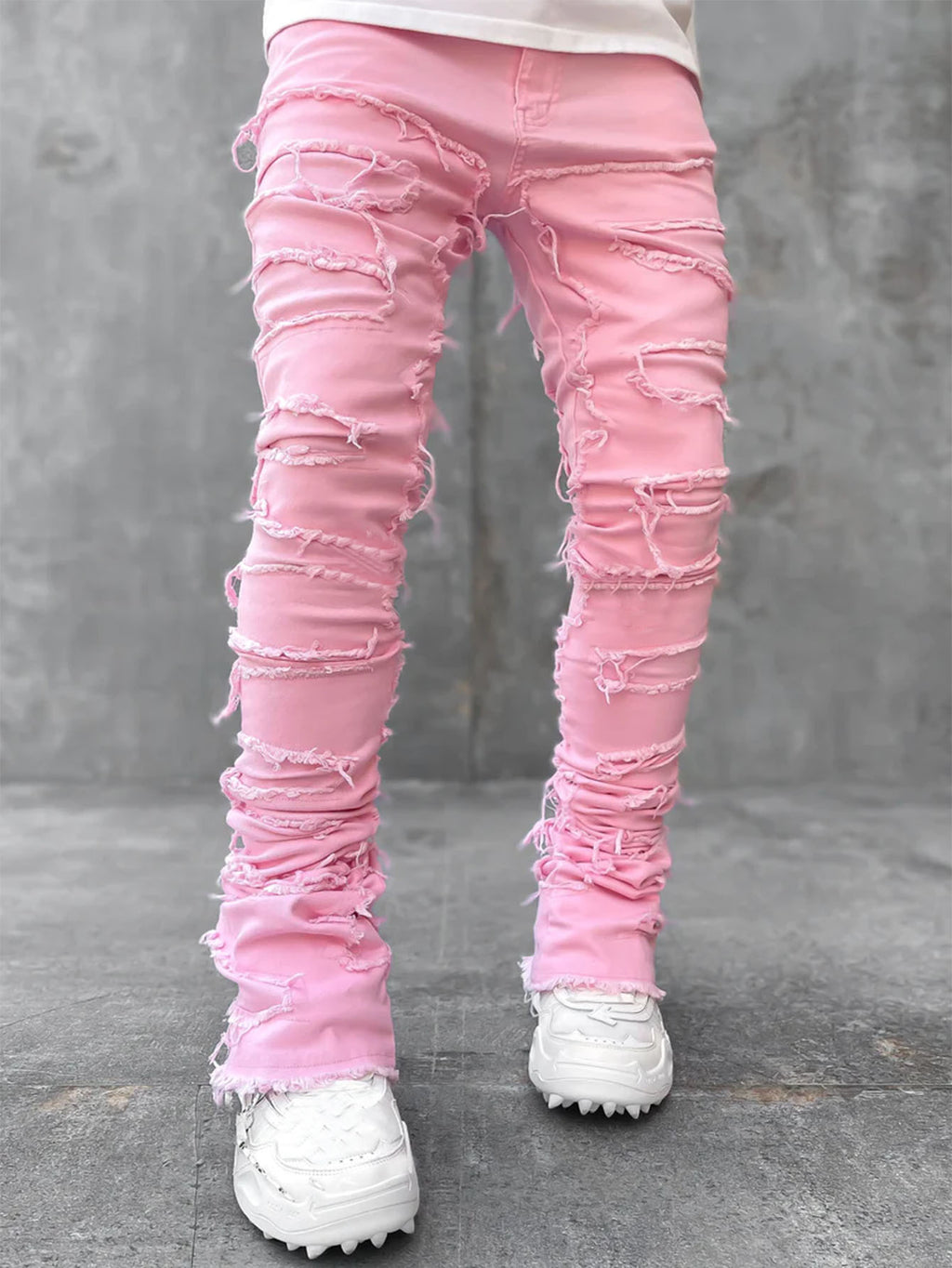 Men’s pink stacked jeans with distressed, ripped details, fringe accents, and a slim-fit design.
