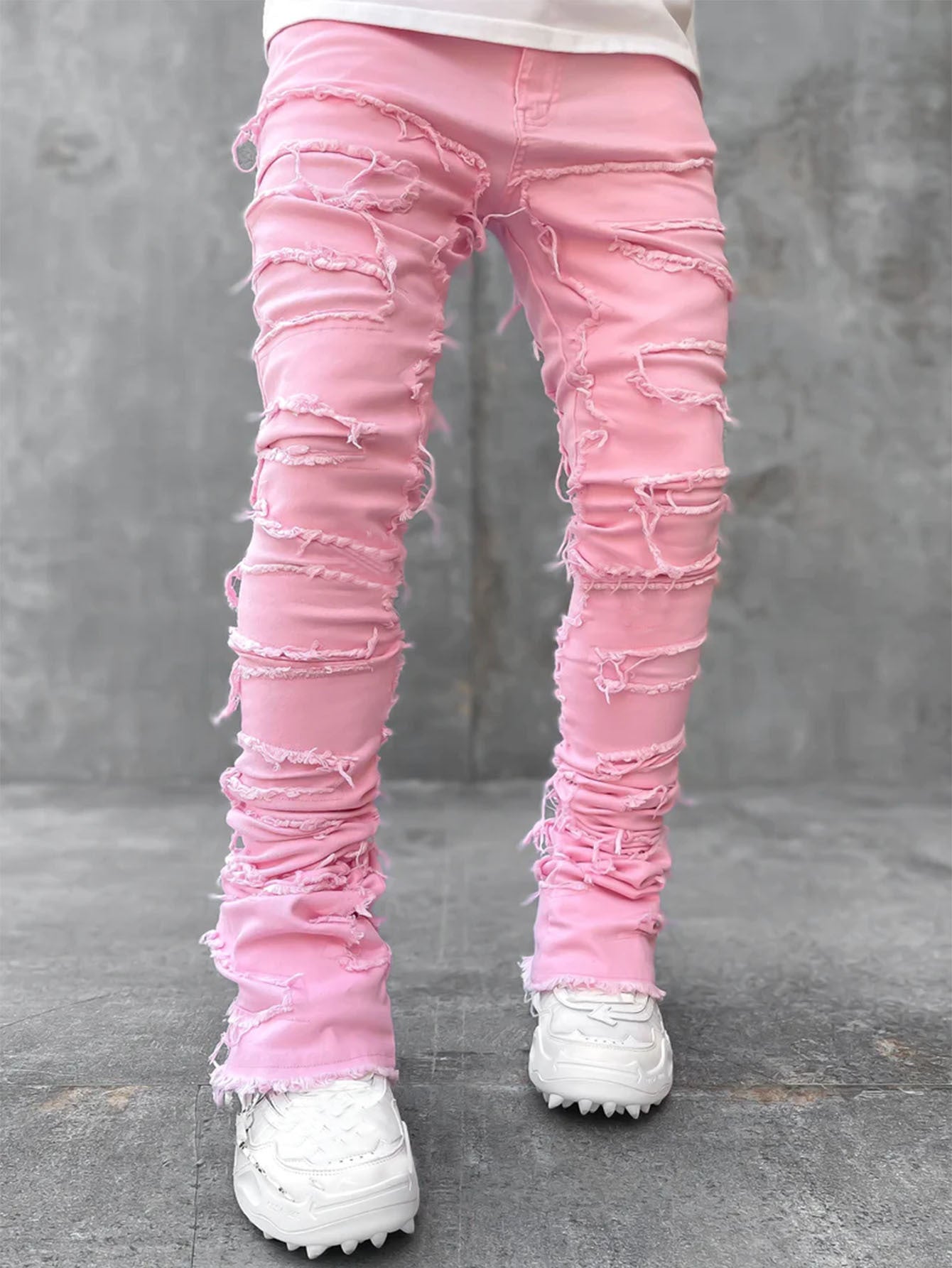 Men’s pink stacked jeans with distressed, ripped details, fringe accents, and a slim-fit design.