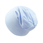 A plain, light blue newborn beanie made of soft, stretchy knit fabric with a gathered top design.