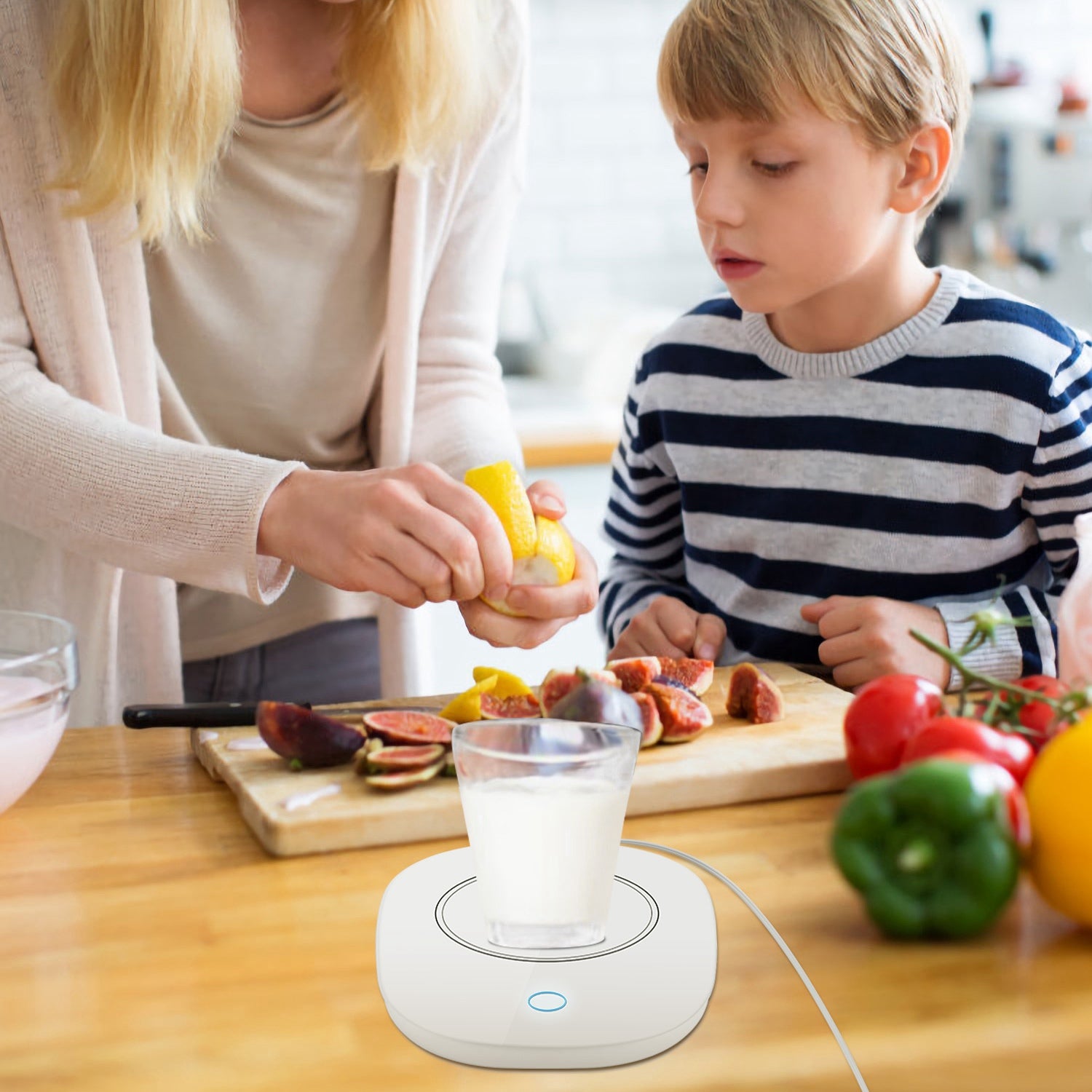 White, square electric beverage warmer with rounded corners on a wooden table, keeping a glass of milk warm.