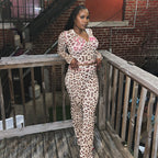 Woman in a leopard print high-waisted pant set with a zip-up hoodie featuring pink contrast stitching.