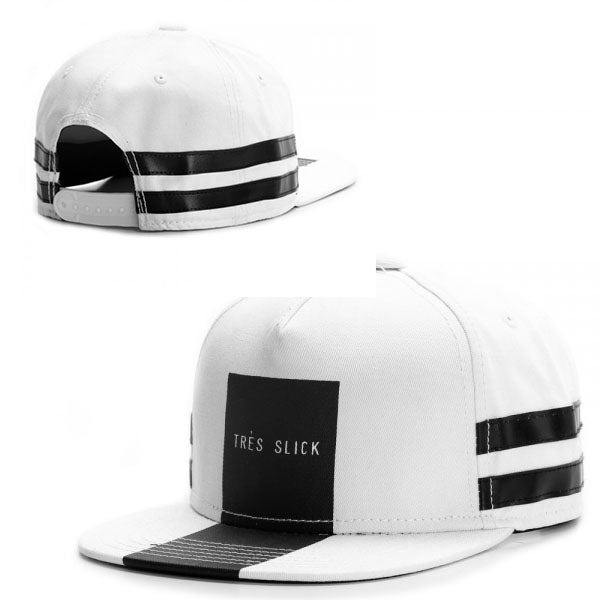 White snapback hat with a black "TRES SLICK" front patch and horizontal black side stripes on a white base.