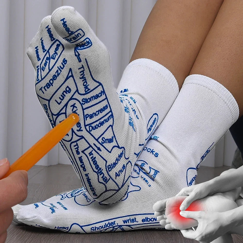 White reflexology socks with blue acupressure point labels, being pointed to by an orange massage tool.