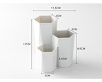 White, hexagonal makeup brush holder with three staggered compartments of varying heights and dimensions.