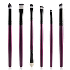 Set of 6 eye makeup brushes with metallic purple handles, black ferrules, and dual-toned white and black synthetic hair.