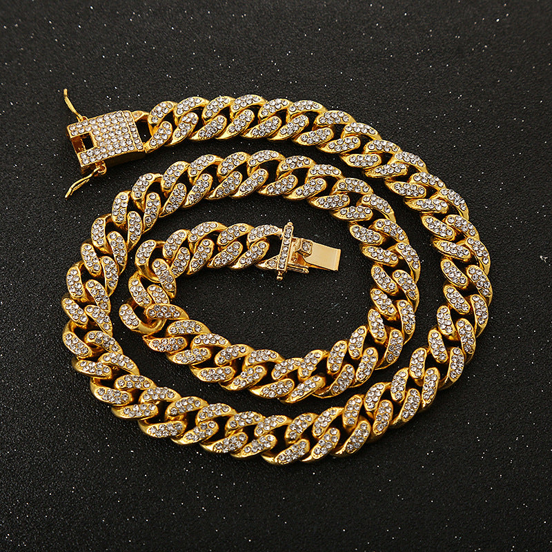 Gold-tone Cuban link chain bracelet featuring embedded sparkling rhinestones and a secure box clasp closure.
