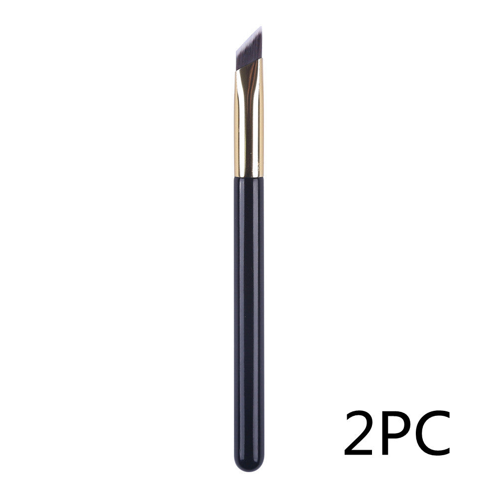 An angled eyebrow makeup brush with a black handle, gold ferrule, and synthetic bristles. Set of 2 pieces.