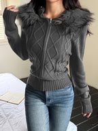 Charcoal gray, zip-up cable knit sweater coat with a faux fur-trimmed hood, long sleeves, and ribbed hem.