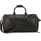 Dark brown vintage-style leather duffle bag with a shoulder strap, carry handles, and side-zippered compartments.