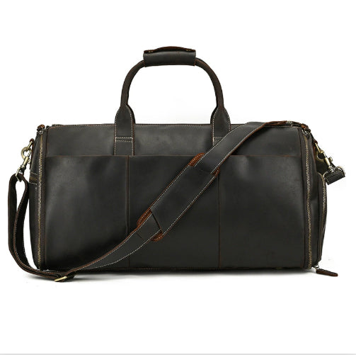 Dark brown leather vintage duffle bag with top handles, adjustable shoulder strap, and brass-tone metal side zippers.