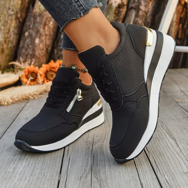 Black lace-up sneakers featuring a perforated design, side zipper, and thick white platform sole with gold accents.