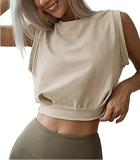 A woman wears a beige, loose-fitting sleeveless crop top with a crew neck and a wide hem band, perfect for fitness.