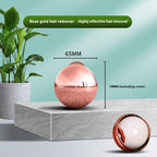 A reflective rose gold, 65mm spherical pet hair remover on a stone surface, featuring an internal white sticky ball.