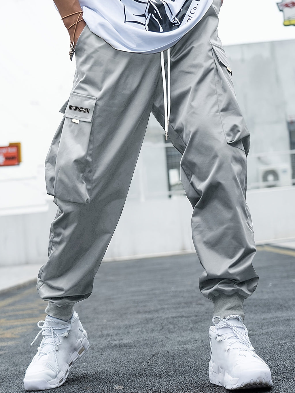 Light gray, relaxed-fit cargo joggers with drawstring waist, side pockets, "AIR BORNE" label, and ribbed ankle cuffs.