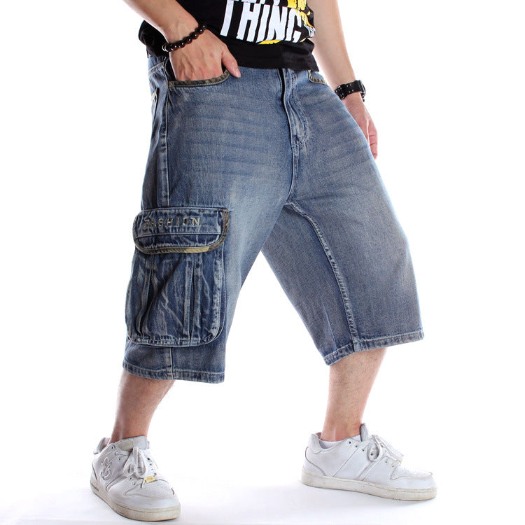 Medium-wash denim cargo shorts featuring a loose hip-hop fit, side utility pockets, and raw-edge detailing.