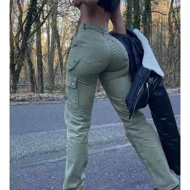 High-waisted olive green cargo pants with side pockets and utility style, worn in an outdoor, wooded setting.