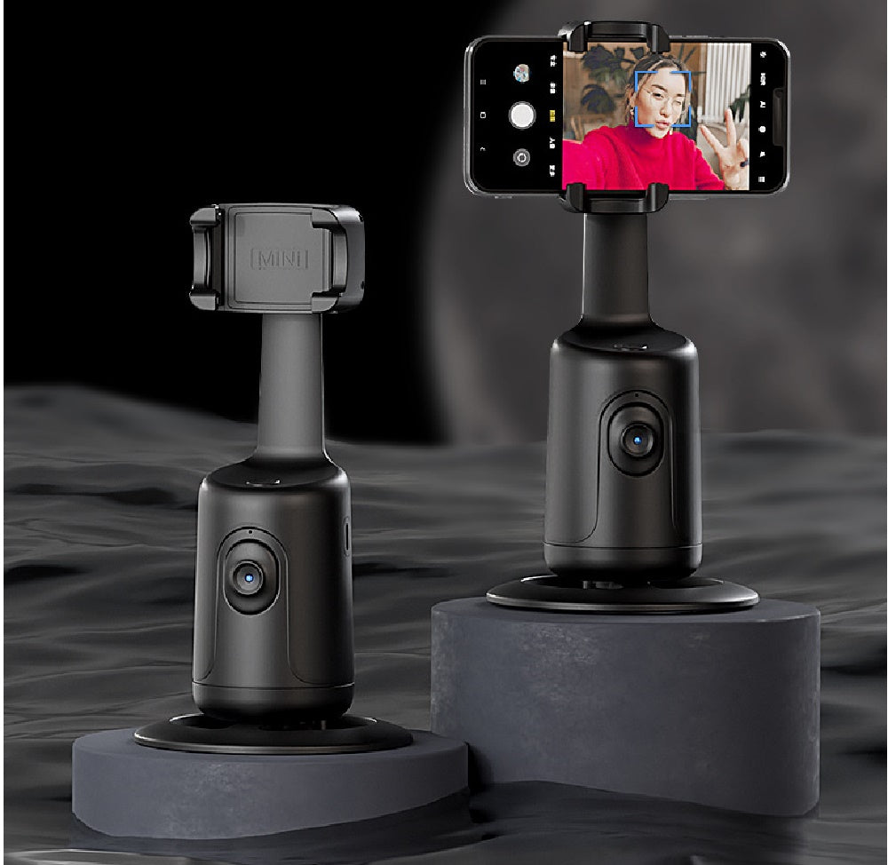 Two black 360-degree auto face-tracking smartphone gimbal mounts on grey pedestals against a dark, rippled background.