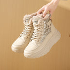 Beige fleece-lined high-top boots with lace-up closure, metallic panels, and chunky, textured platform soles.