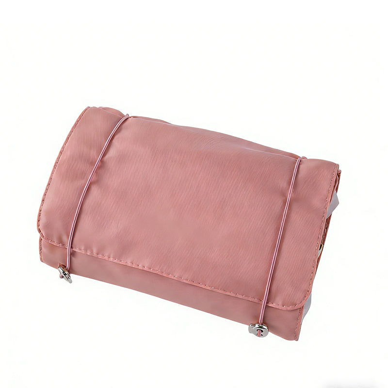 Dusty pink 4-in-1 travel storage bag with a fabric exterior and thin elastic straps, isolated on a white background.