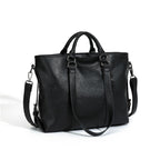 Large black soft leather tote bag with dual handles, silver hardware, and a detachable shoulder strap.