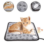A grey paw-print pet heating pad with a chew-resistant cord, featuring waterproof material and a resting orange cat.