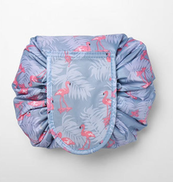 Drawstring cosmetic bag in gray with a pink flamingo and leaf print, featuring a secure flap closure.