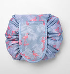 Drawstring cosmetic bag in gray with a pink flamingo and leaf print, featuring a secure flap closure.
