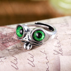 Silver-toned metal hip hop ring shaped like a frog with large, striking green eyes and a small protruding tongue.