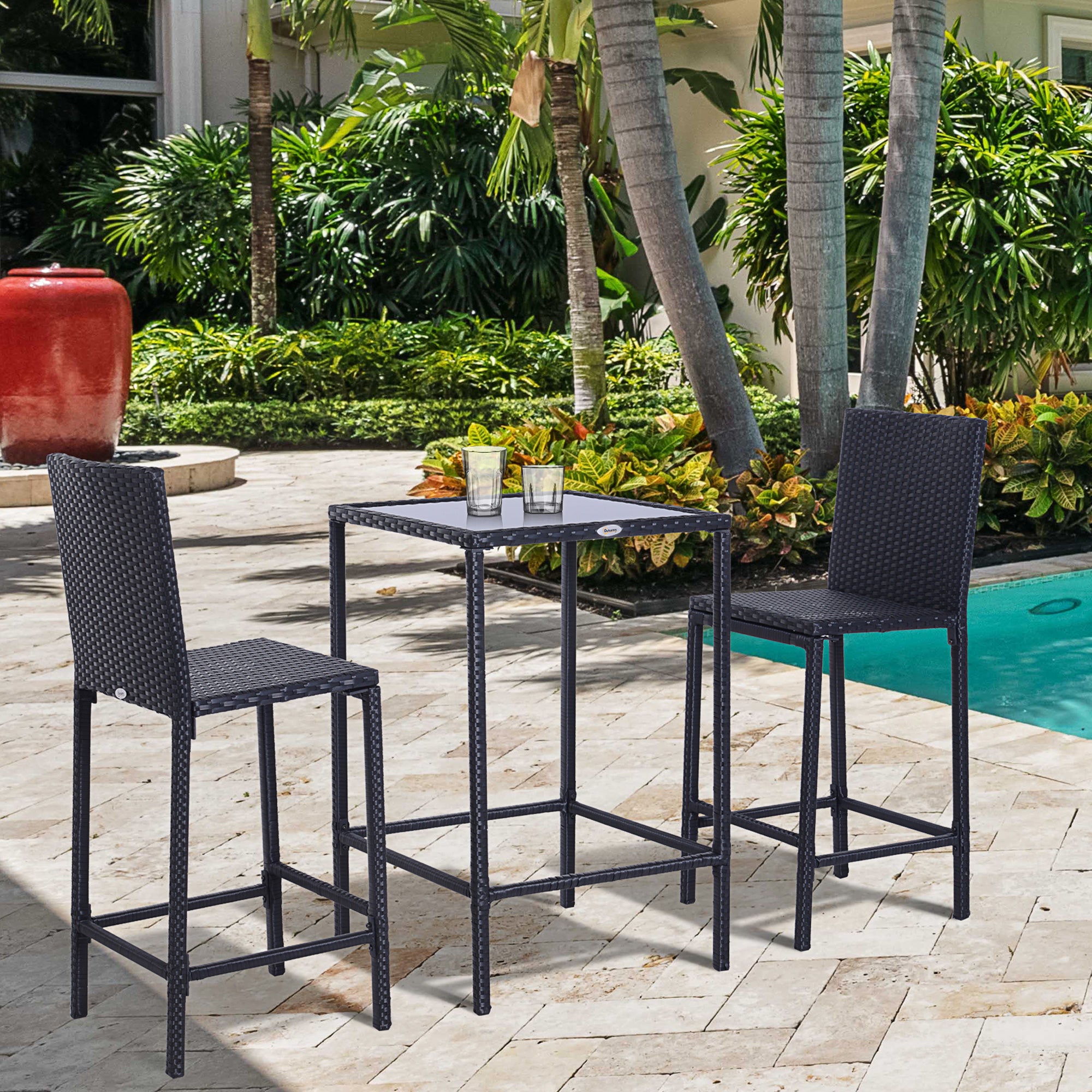 3-piece black rattan bar set with two high-back stools and a square glass-top table on a patio near a pool.