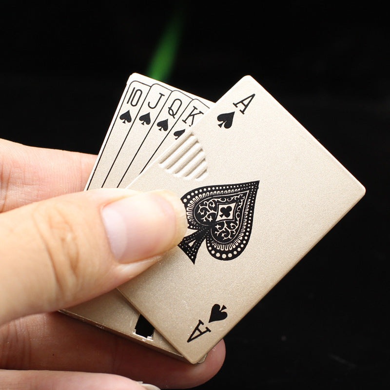 A hand holding a brushed gold, metal playing card-shaped electronic windproof lighter with an Ace of Spades design.