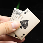 A hand holding a brushed gold, metal playing card-shaped electronic windproof lighter with an Ace of Spades design.
