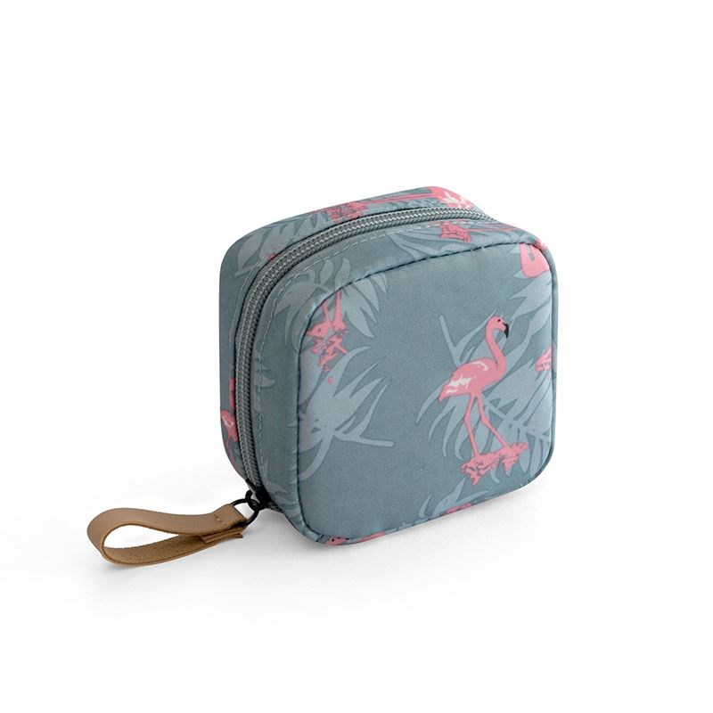 Blue fabric makeup bag with a pink flamingo and palm leaf print, featuring a sturdy zipper and tan wrist strap.
