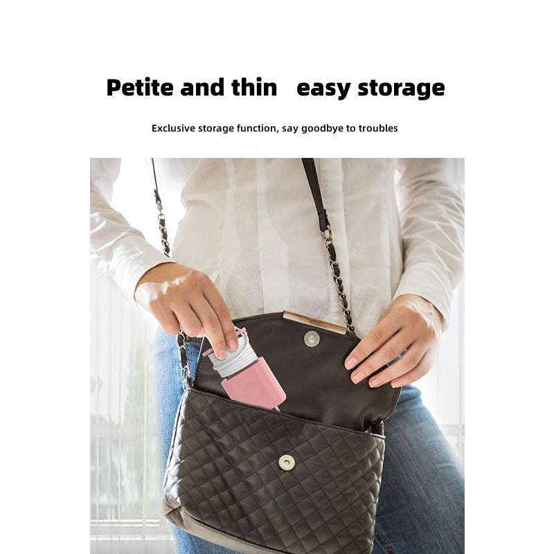 A person placing a pink silicone charger organizer case with a wrapped white cable into a small black handbag.