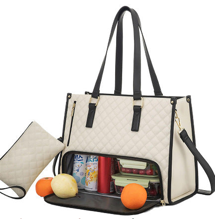 Quilted off-white tote with black trim, black handles, and insulated base compartment filled with food and drinks.