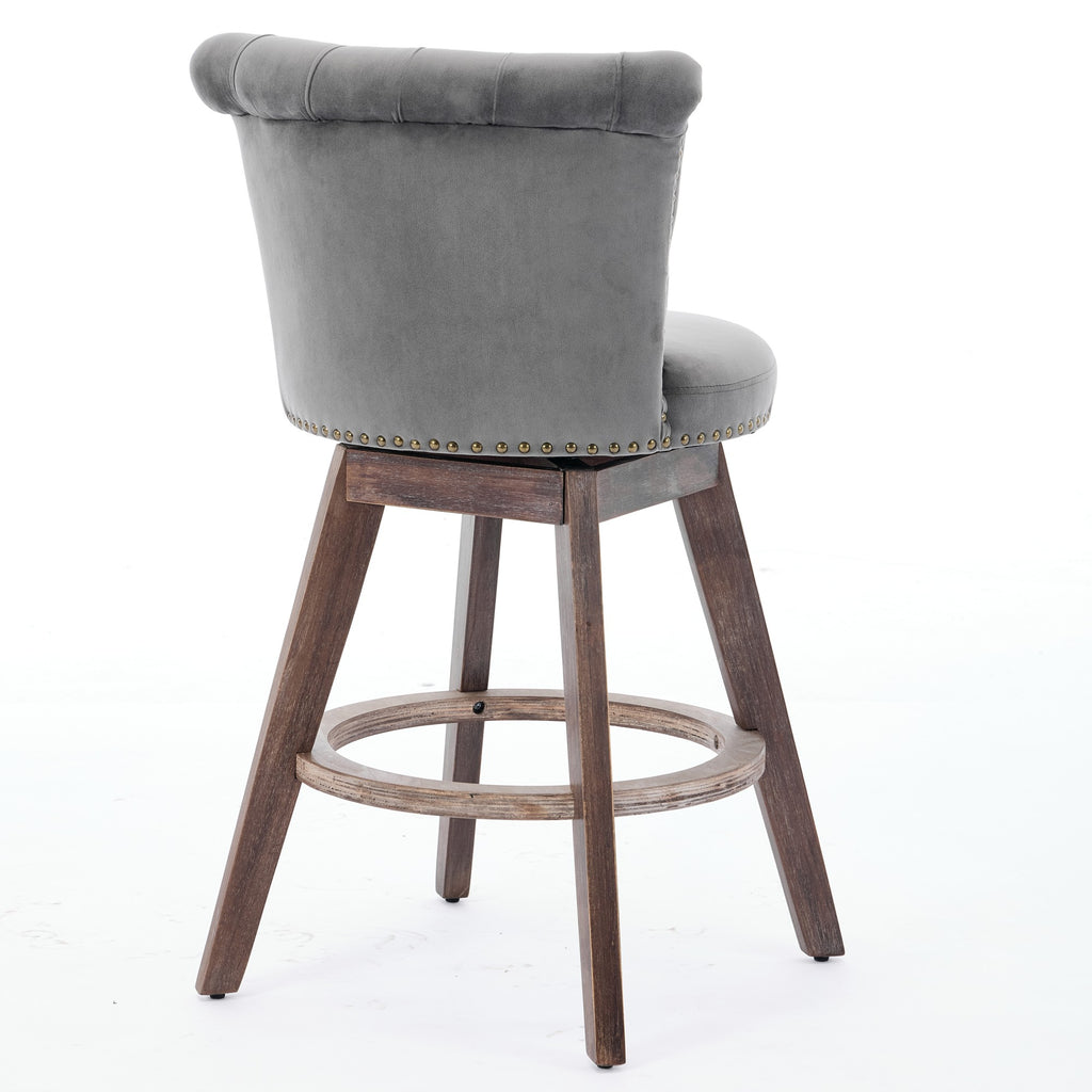 Gray velvet swivel counter stool with tufted back, nailhead trim, and dark wood legs on a white background.