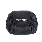 Black satin, drawstring cosmetic bag with a flap featuring white "VELY VELY" embroidery.