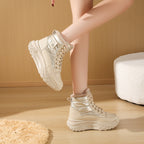 Beige, fleece-lined high-top boots with a metallic quilted finish, lace-up front, and chunky, textured platform soles.